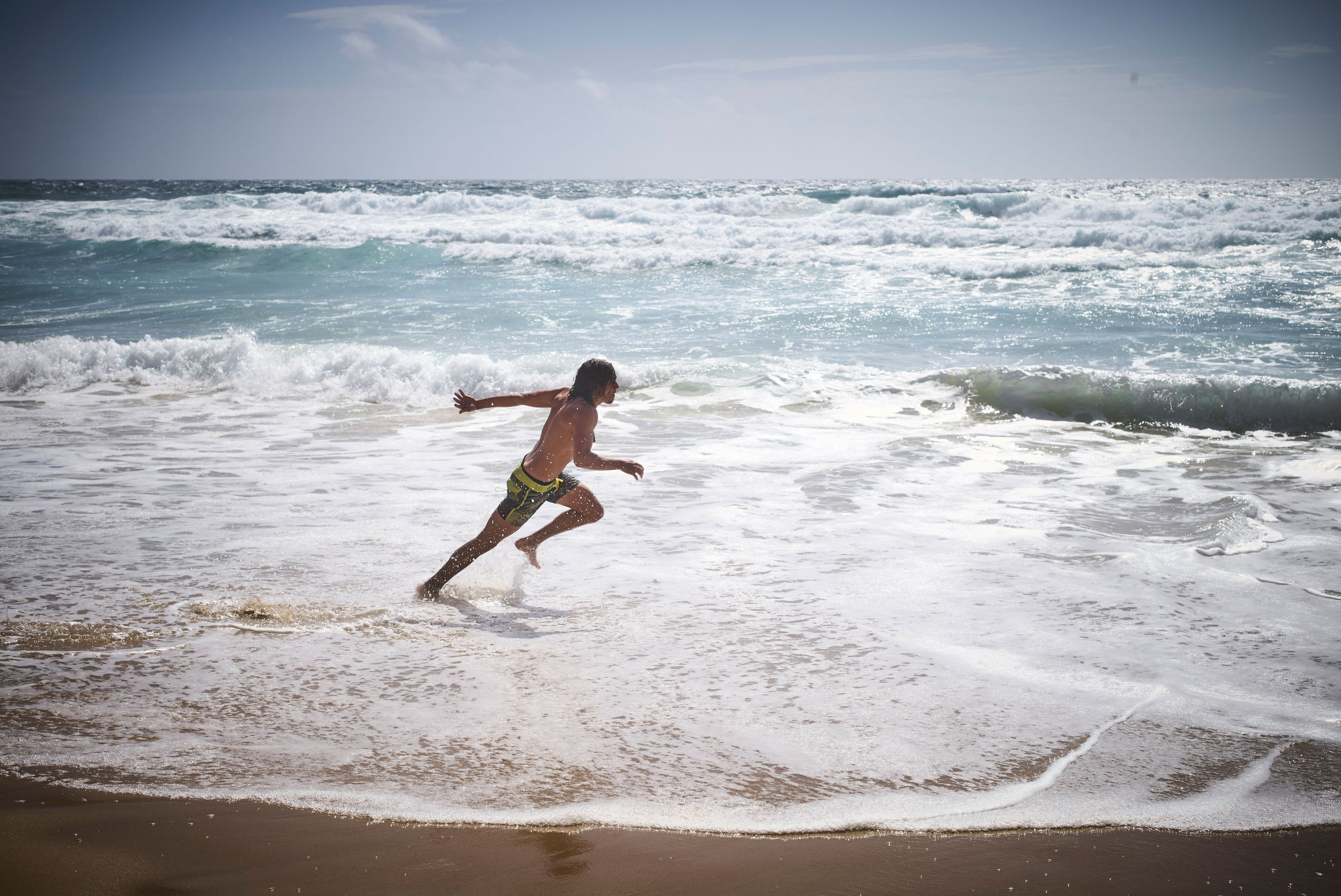 Ein junger Mann am Strand von Portugal beim Schaumsurfen