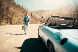 Sara is an Italian woman with a calm, natural presence. She is self-confident, clear-headed, and has a touch of rebellion about her. The setting was simple: dusty roads, an old Alfa, soft light, no big setup.