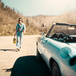 Sara is an Italian woman with a calm, natural presence. She is self-confident, clear-headed, and has a touch of rebellion about her. The setting was simple: dusty roads, an old Alfa, soft light, no big setup.
