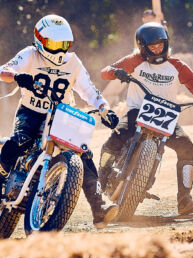 Two flat track riders, numbers 38 and 227, racing side by side on the dirt track at Wheels and Waves in Biarritz